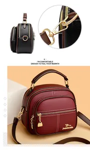 Detail of round leather handbag with layered zippers and gold kangaroo logo emblem
