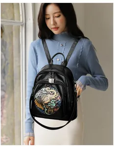 Close-up of artistic colorful elephant pattern embossed on a black leather backpack
