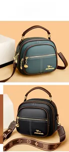 Detail of round textured leather crossbody bags in black and green with gold kangaroo logo