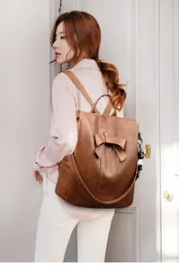 Details des braunen Vintage-Lederrucksacks mit großer Schleife und Panda-Anhänger