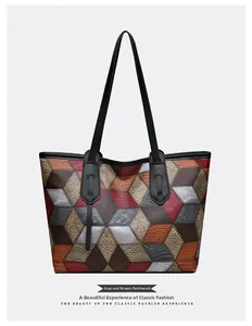 Detail of the gray and brown patchwork leather texture on a large capacity tote bag