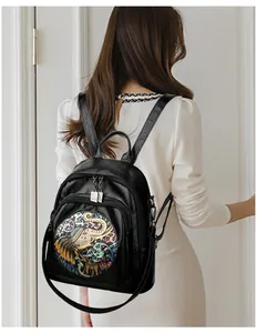 Close-up of black leather backpack featuring colorful ethnic elephant embroidery detail