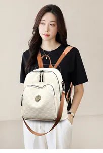 Détail de la texture tissée à carreaux et logo en métal sur un sac à dos crème