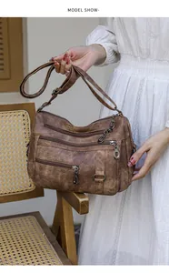 Detailed view of the vintage brown multi-pocket leather crossbody bag with metal zippers