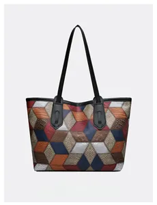 Detail of multi-color geometric patchwork tote bag with various embossed leather textures