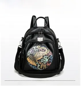 Detail of black leather backpack with colorful 3D elephant relief and silver zippers