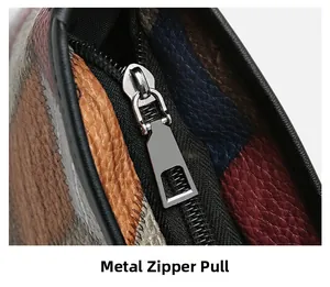 Detail shot of silver hardware zipper puller on a multi-color patchwork leather handbag