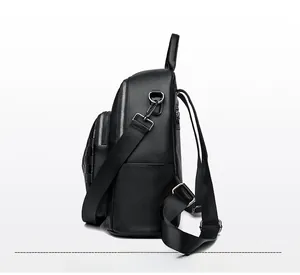 Vue latérale d'un sac à dos noir en cuir grainé avec fermetures éclair argentées