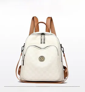 Détail de la texture damier sur le sac à dos en cuir blanc cassé avec plaque dorée