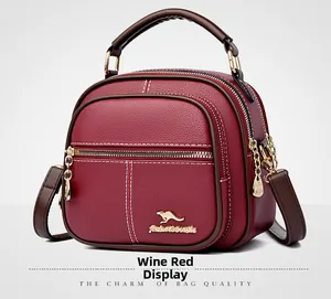 Detail view of burgundy leather handbag showing pebbled texture and triple zipper layers