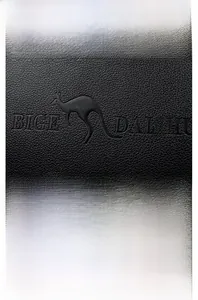 Close-up of black litchi texture leather backpack with gold kangaroo logo and hardware