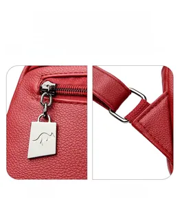 Detail of silver kangaroo zipper pull and metal rings on red lychee leather backpack