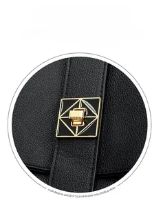 Close-up of golden square lock on black litchi textured leather backpack for women