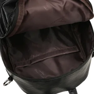 Internal view of black textured leather backpack with brown lining and spacious compartments