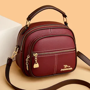 Classic wine red round crossbody bag in lychee pattern leather with golden hardware