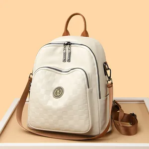Sac à dos crème à motif damier avec bretelles en cuir marron et emblème en métal rétro
