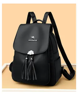 Detail of black pebbled leather backpack featuring silver kangaroo plaque and leather tassels