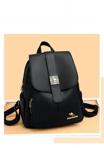 Detail of black pebbled leather texture with gold kangaroo logo on a women's backpack