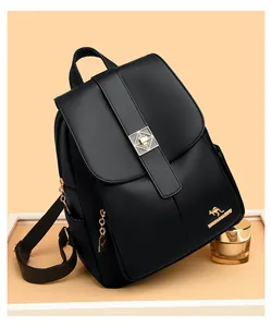 Detailed view of women's black leather backpack with silver lock and gold hardware