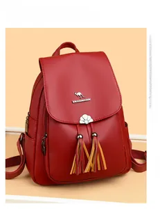Detail of red lychee texture backpack with metal kangaroo logo and long fringe tassels