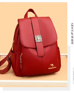 Detail of burgundy lychee grain leather backpack with golden kangaroo logo and metal buckle
