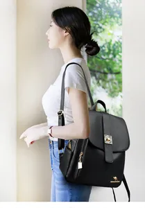 Detail of black pebbled leather backpack showing golden kangaroo logo and metal lock