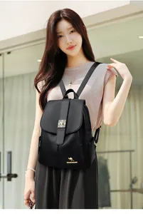 Detail of black pebbled leather backpack with gold geometric buckle and kangaroo logo