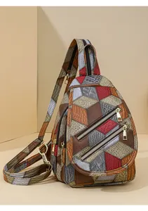Detail of color-block sling bag featuring embossed faux leather and gold metal zippers