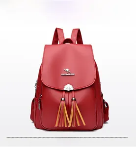 Front view of red faux leather backpack with kangaroo logo and decorative tassels