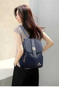 Close-up of navy blue pebbled leather backpack with golden kangaroo logo and hardware