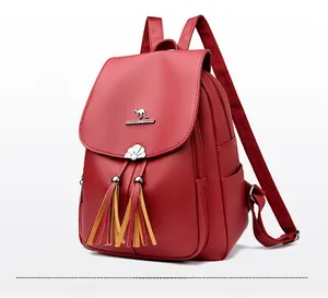 Close-up of red soft leather backpack featuring metal kangaroo logo and colorful tassels