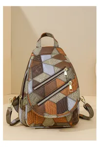 Detail of geometric patchwork chest bag featuring crocodile and lychee leather textures