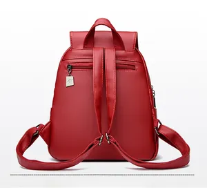 Rear view of a red leather backpack with an anti-theft zipper pocket and metal charm