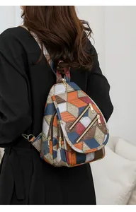 Detail of multi-functional patchwork backpack featuring colorful leather and gold zippers