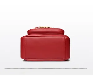 Detailed base of red lychee leather backpack with embossed kangaroo logo and branding