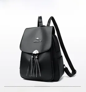 Detail of black pebbled leather backpack with silver kangaroo logo and tassel charm