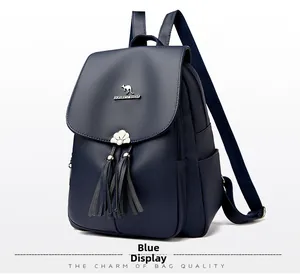 Detail of blue faux leather backpack with litchi texture and metallic tassel