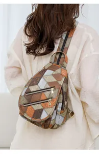 Detail of geometric patchwork chest bag featuring snakeskin texture and golden zippers