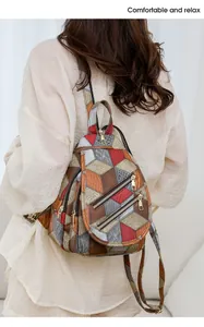 Detail of bohemian patchwork leather bag with crocodile texture and metal zippers
