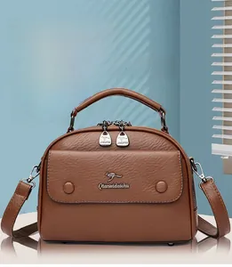 Detail of brown litchi pattern leather handbag showing soft texture and logo