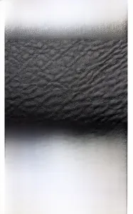 Detail of black textured leather bag with durable stitching and magnetic buckle closure