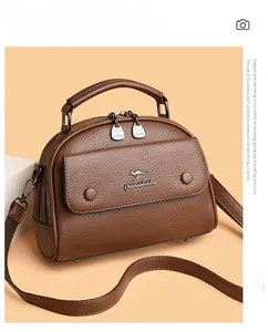 Detail view of the brown textured leather surface and kangaroo logo on the handbag