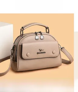 Detail of beige lychee pattern doctor bag with gold kangaroo logo and dual zippers