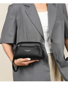 Nahaufnahme der schwarzen Tasche aus Leder mit Litschimuster und silbernem Zipper