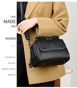 Close-up of black lychee grain leather handbag with gold kangaroo logo and zipper