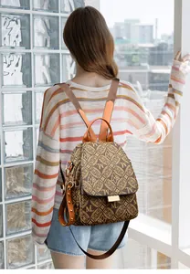 Close-up of vintage printed backpack with monogram texture and leather details