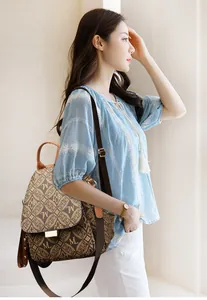 Close-up of vintage brown monogram pattern leather backpack with gold metal buckle