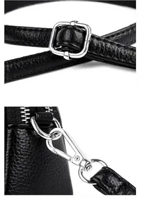 Details der silbernen Metallschnallen und verstellbaren Haken an schwarzer Ledertasche