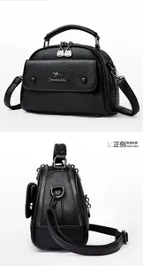 Detailed view of the black leather doctor bag with a metal kangaroo logo and dual zippers
