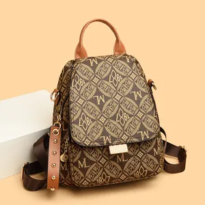 Retro brown jacquard backpack with M 1987 print and golden hardware on white podium